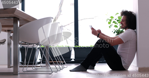 Image of young man using a tablet at home