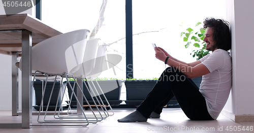 Image of young man using a tablet at home