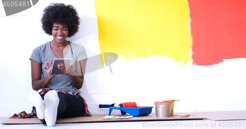 Image of black female painter sitting on floor