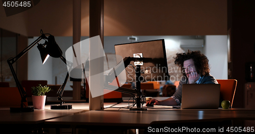 Image of man working on computer in dark office