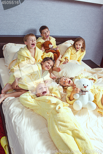 Image of Large group of friends taking goog time on bed