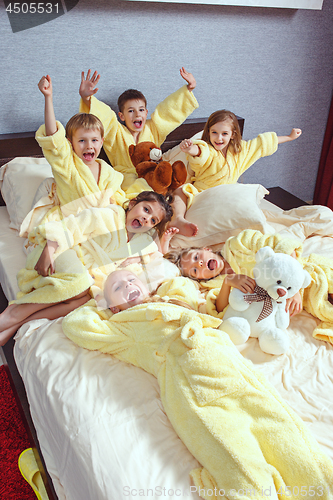 Image of Large group of friends taking goog time on bed