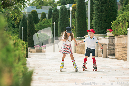 Image of Portrait of a charming teenage couple roller-skating together