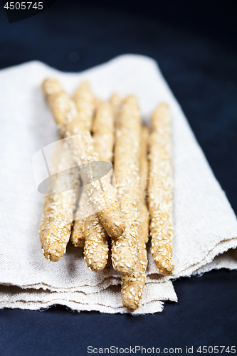 Image of Italian grissini or salted bread sticks with sesame on linen nap