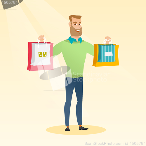 Image of Young caucasian man holding shopping bags.