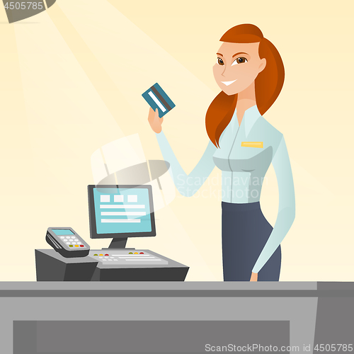 Image of Caucasian cashier holding a credit card.