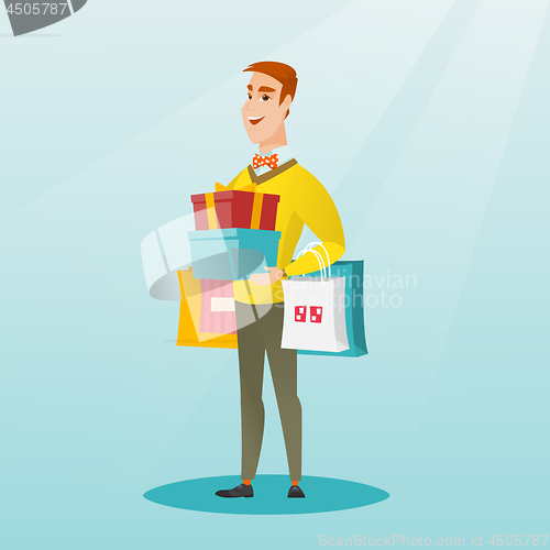 Image of Caucasian man holding shopping bags and gift boxes