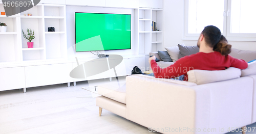 Image of Young couple on the sofa watching television