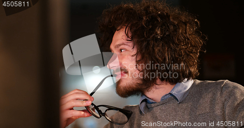 Image of man working on computer in dark office