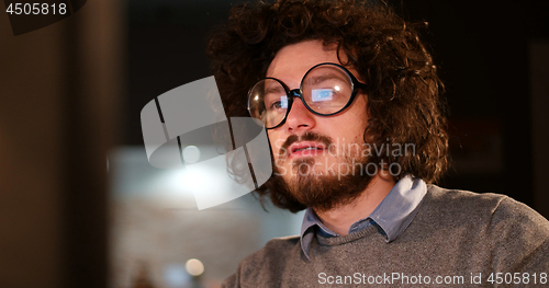 Image of man working on computer in dark office