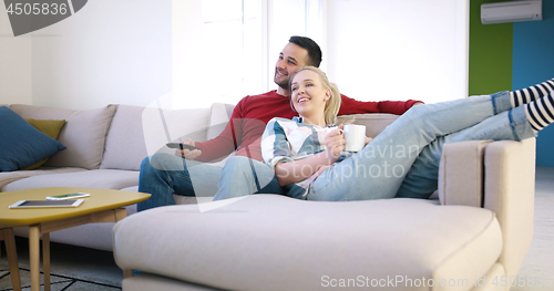 Image of Young couple on the sofa watching television