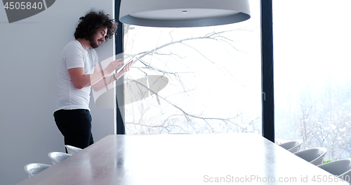 Image of young man using a tablet at home