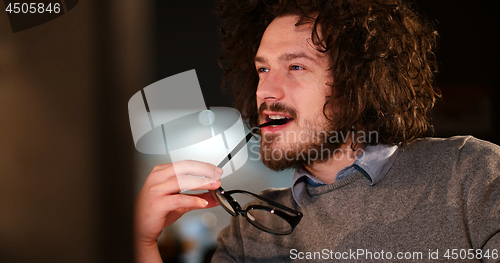 Image of man working on computer in dark office