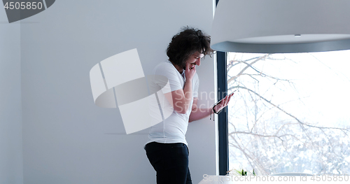 Image of young man using a tablet at home