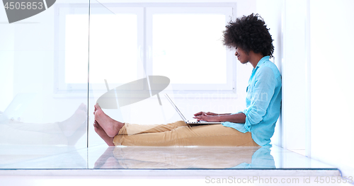 Image of black women using laptop computer on the floor