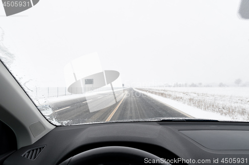 Image of View from a car to road with snow