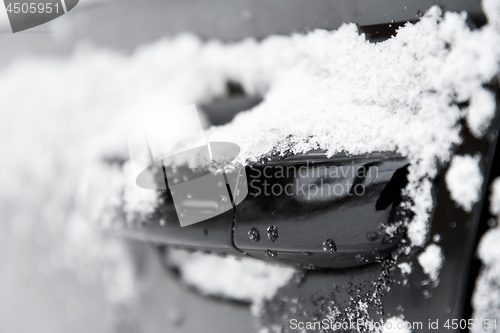 Image of closeup of a doorknob of a car with snow