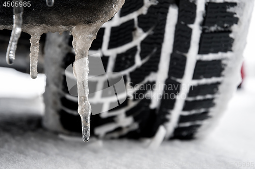 Image of closeup of a tyre of a car with icicle