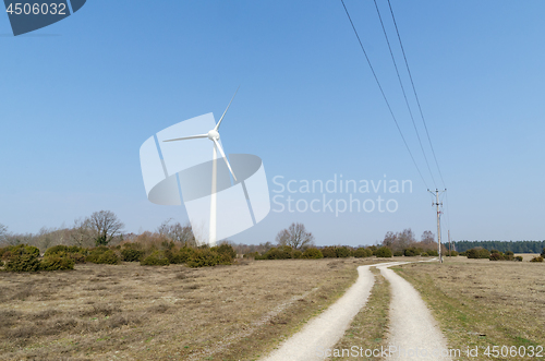 Image of Windmill and power lines in a rural landscape