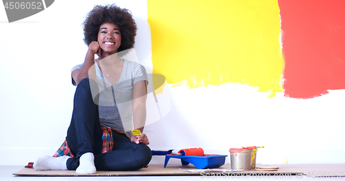 Image of black female painter sitting on floor