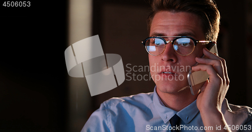 Image of man using mobile phone in dark office