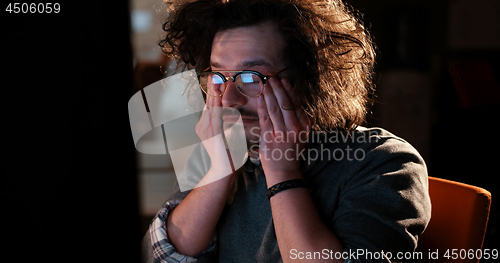 Image of man working on computer in dark office