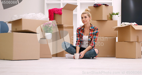 Image of woman with many cardboard boxes sitting on floor