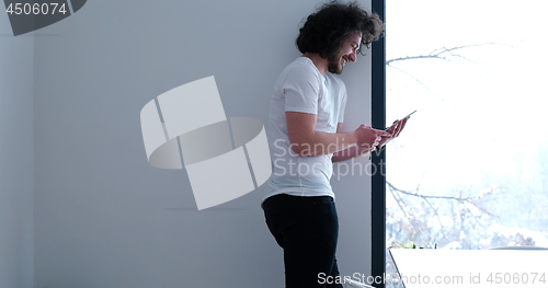 Image of young man using a tablet at home