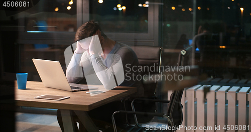 Image of man working on laptop in dark office