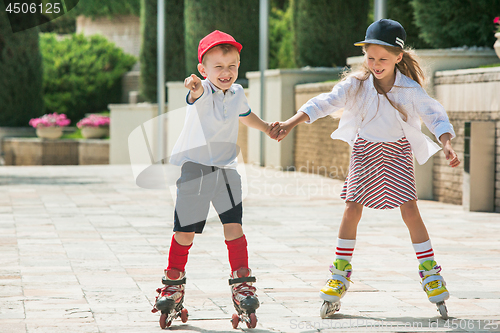 Image of Portrait of a charming teenage couple roller-skating together