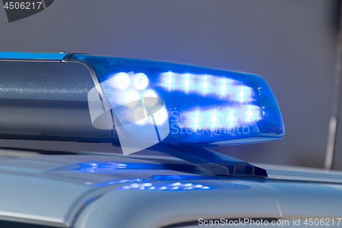Image of Detail shot of a glowing blue light on a police car