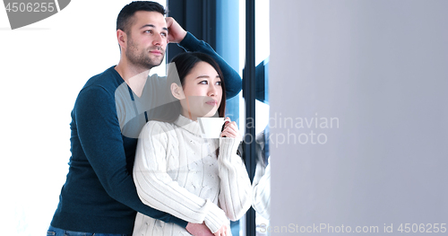 Image of multiethnic couple relaxing at modern home indoors