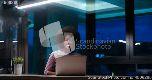 Image of black businesswoman using a laptop in night startup office