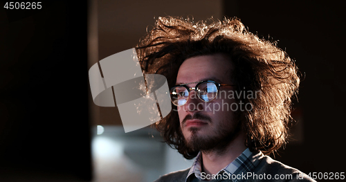 Image of man working on computer in dark office