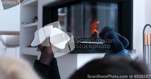 Image of Young couple sitting in front of fireplace