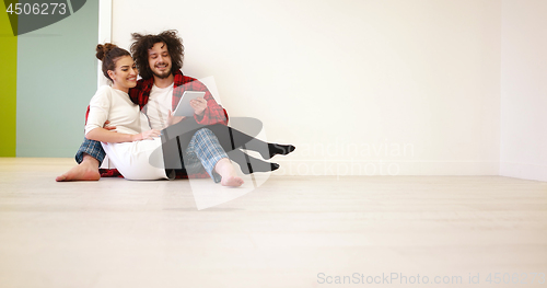 Image of Young Couple using digital tablet on the floor