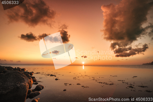 Image of Sunrise over the sea by the shore with rocks