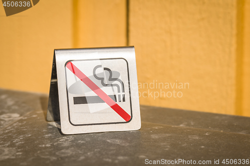 Image of No smoking metal sign on a table