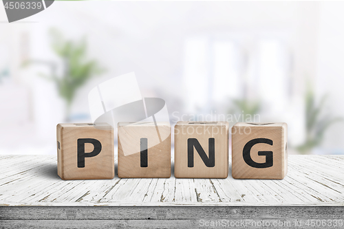 Image of Ping sign on a bright room on a wooden desk