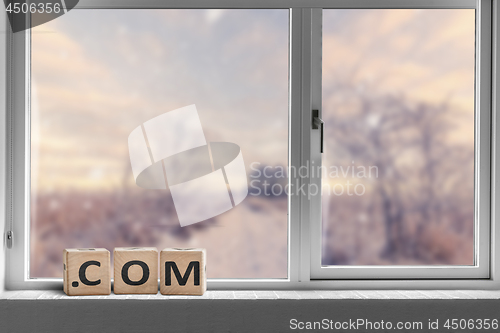 Image of Com sign in a bright window with a view