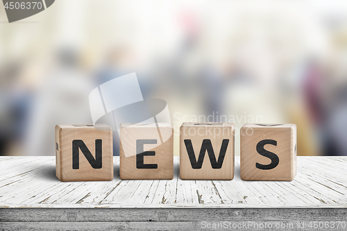 Image of News sign on a worn wooden table