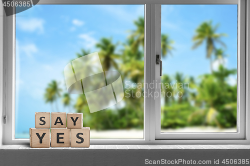 Image of Say yes sign in a window on a tropical beach