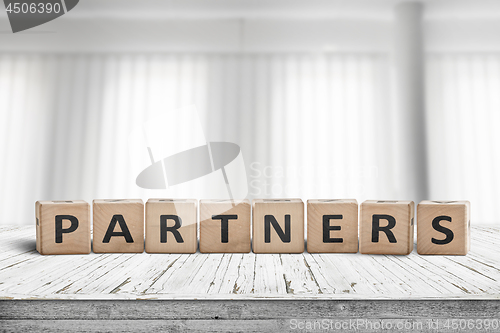 Image of Partners sign on a desk in a bright office