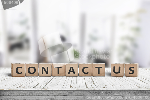 Image of Contact us sign on a wooden desk