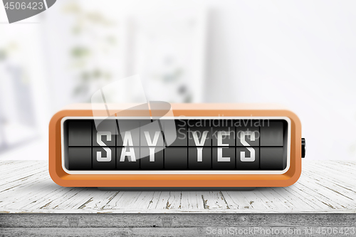 Image of Say yes message sign on a wooden desk