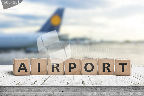 Image of Airport word sign on a wooden surface with a plane