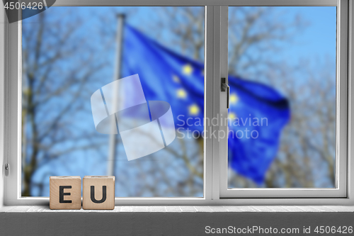 Image of EU sign in a window with the European union flag