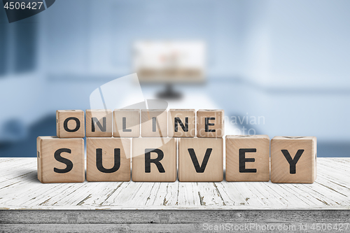 Image of Online survey sign on a table in a blue room