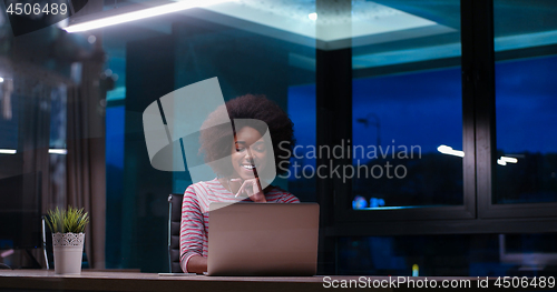 Image of black businesswoman using a laptop in night startup office