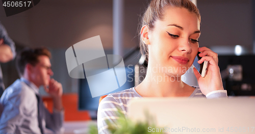 Image of woman using mobile phone in dark office